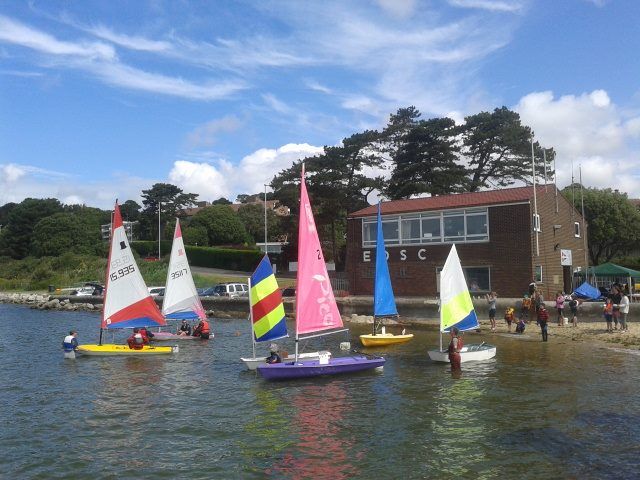 Junior sailors launching dinghies in front of the East Dorset Sailing Club clubhouse